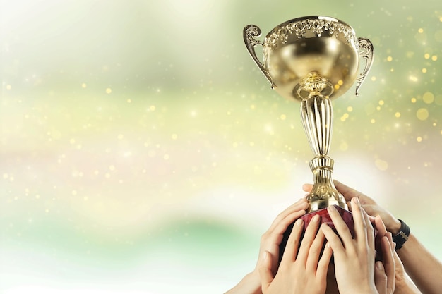 Hand of kid holding champion cup on glossy background
