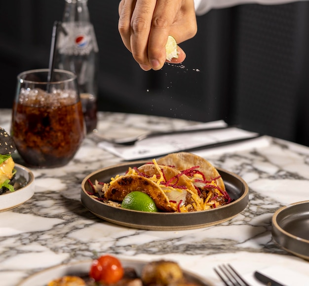 Hand knijpen een halve citroen op een bord crunchies in een luxe restaurant