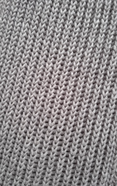 Hand-knitted fabric on knitting needles.