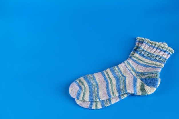 Hand knitted warm winter socks on blue background