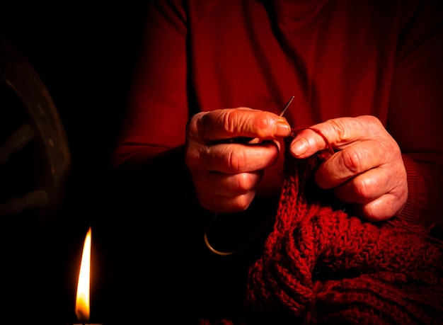 Foto lavoro a maglia a mano con filo di lana a lume di candela