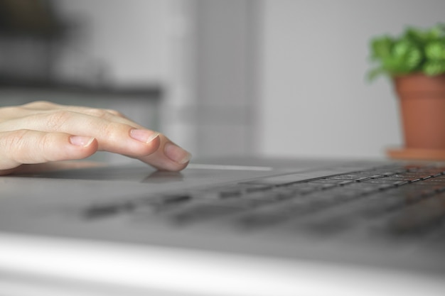 Hand and laptop keyboard close-up. Businesswoman or student using computer at home. Online learning or internet marketing, freelance workspace concept background photo