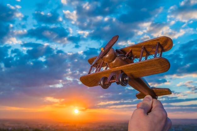 The hand launch toy plane on the background of a sunset