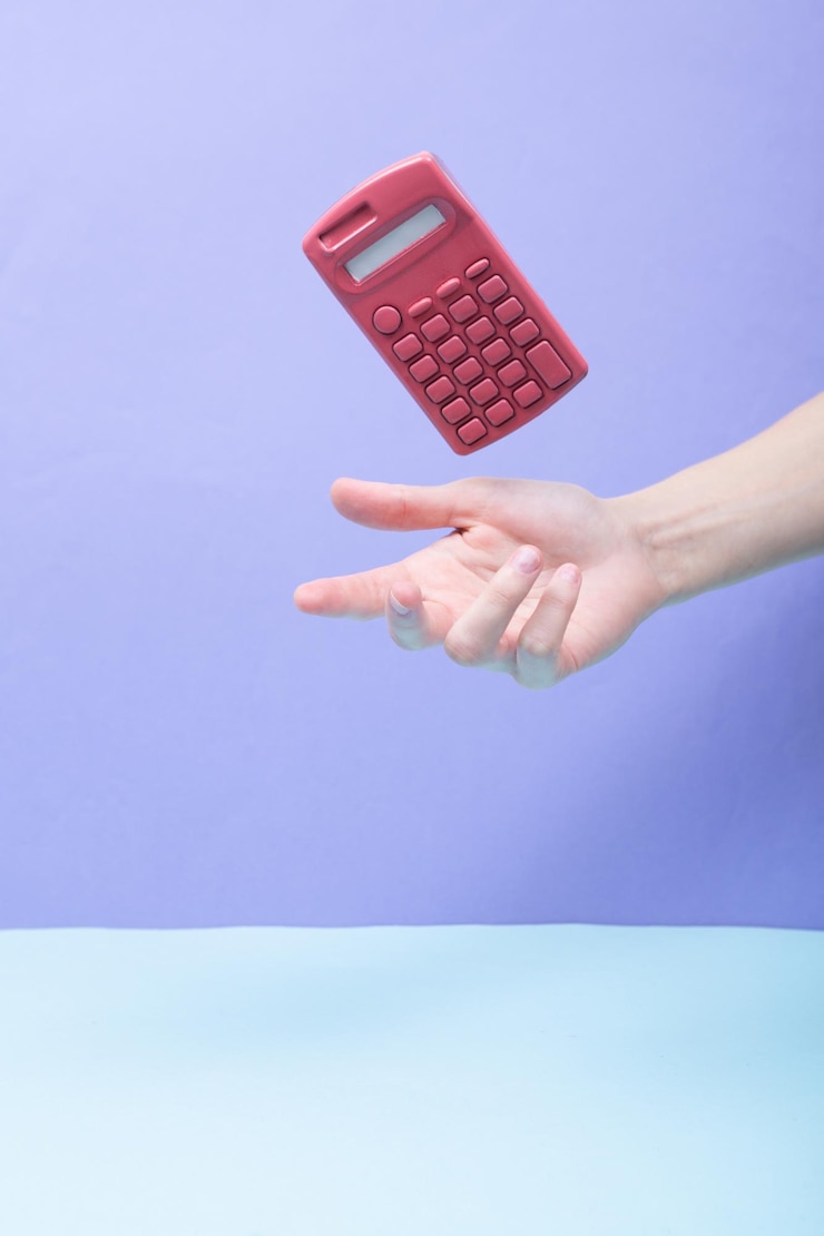 Photo hand and levitating pink calculator on colored background minimalistic still life creative layout concept art