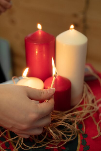 Photo hand lighting a set of colored candles