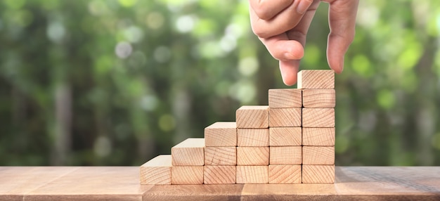 Hand liken person stepping up  toy staircase wood