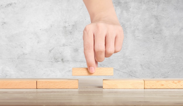 Hand liken person stepping up wood block stacking as step stair