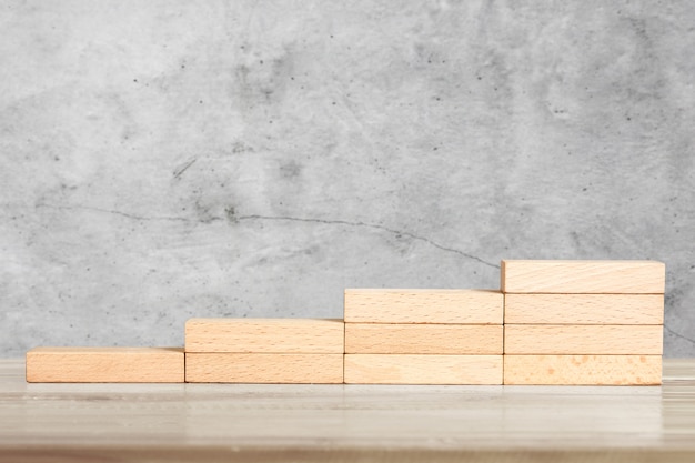 Hand liken person stepping up wood block stacking as step stair