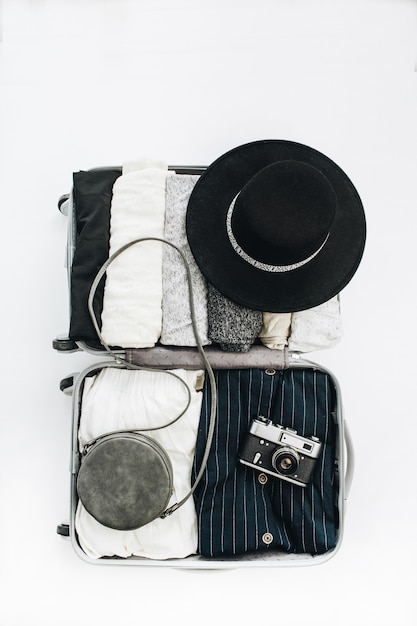 Foto bagaglio a mano con vestiti femminili alla moda viaggio concetto di moda