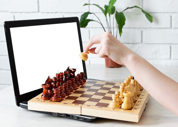 Hand maakt een zet in het schaakspel op het schaakbord in videochat online.