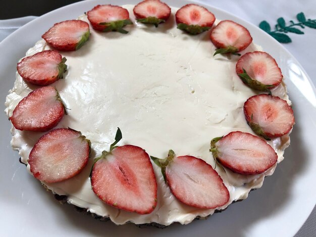 Foto torta al formaggio senza forno fatta a mano con topping di fragole