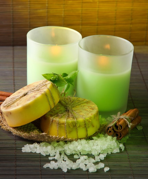 Мыло ручной работы и свечи на фоне бамбуковой циновки