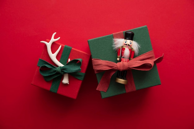 Hand made stylish Christmas gift box presents tied with red ribbon and a festive reindeer antler and toy.