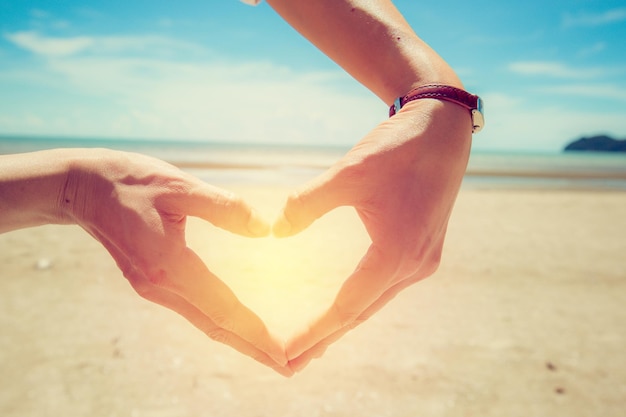 hand maken hartvorm op tropisch strand