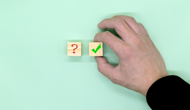Hand making a choice between two cubes with yes and no on\
neutral background