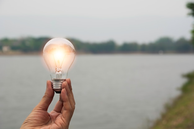 Hand of male holding a light bulb and copy space for accounting, ideas and creative concept.