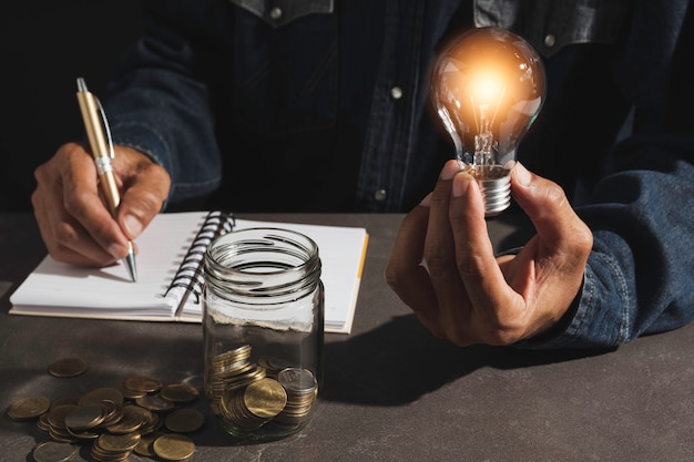 Hand of male holding a light bulb and copy space for accounting