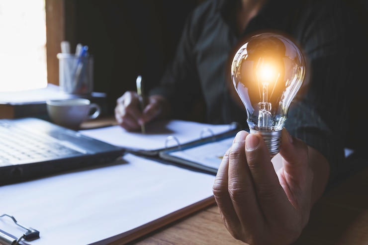 Photo hand of male holding a light bulb and writing for idea and creative concept.