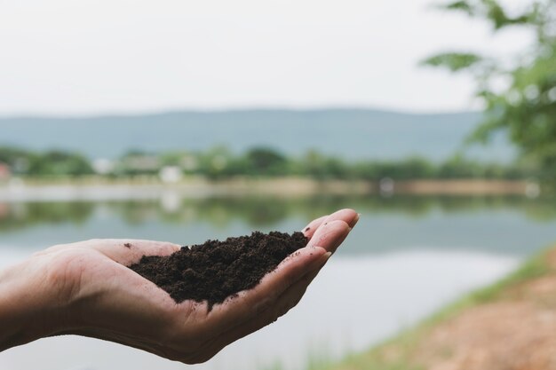 Photo hand of male holding soil in the hands for planting