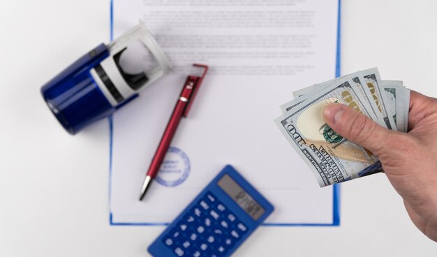 Photo hand of man give us dollars on the background of documents and rubber stamp