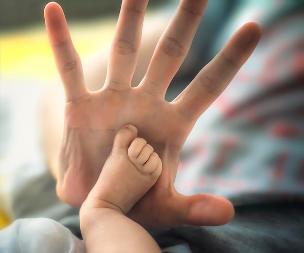 The hand of a man gives five to a small child's leg selective focus