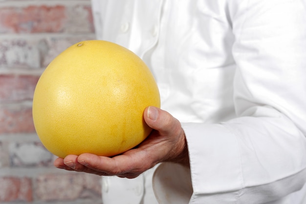 Hand man holding grapefruit