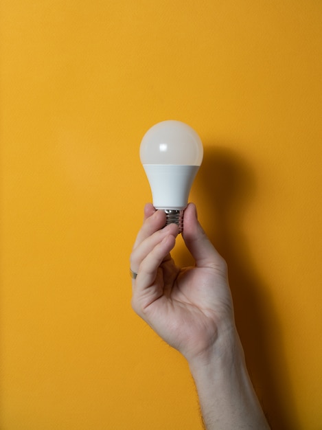 Foto la mano di un uomo che tiene una lampadina per innovazione e concetto creativo.