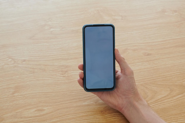 Hand of man holding smartphone with empty screen