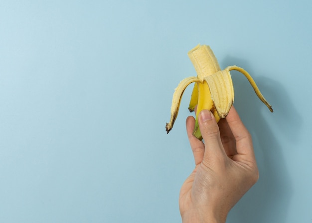 Hand a man holds banana.