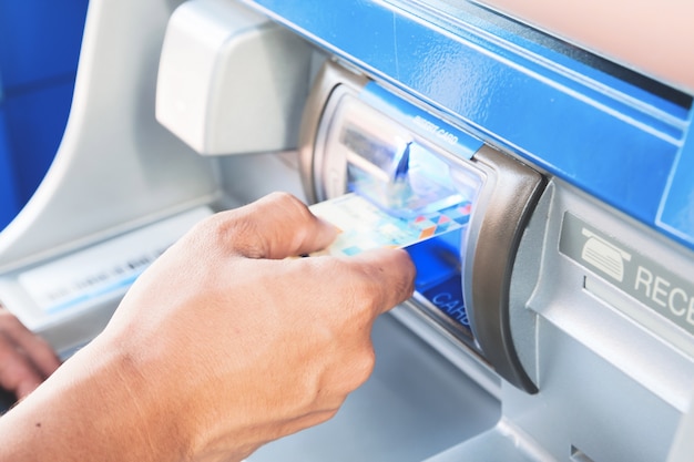ATM 기계에 남자 삽입 카드의 손