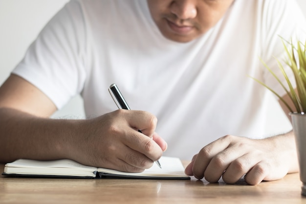  hand of man recording information on notebook