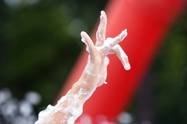 The hand of a man in a soap foam at the concert. leisure and relaxation