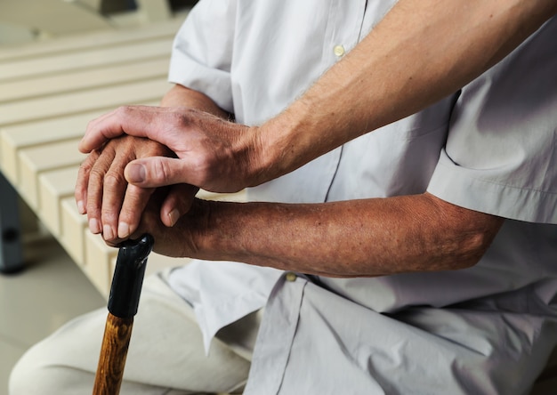 hand of man touching hands elderly man
