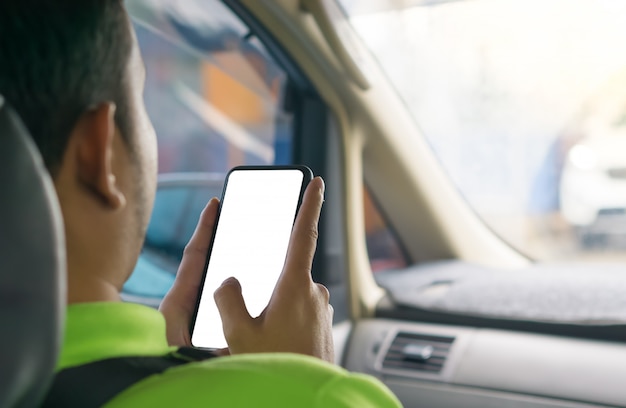 Photo the hand of a man using a smartphone in a car.