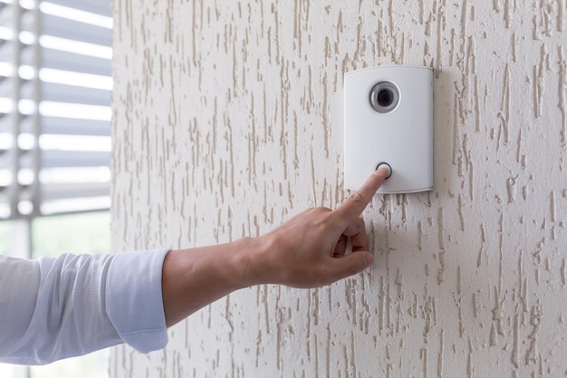 hand of a man in a white shirt pressing the button of a door