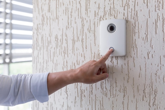 Hand of a man in a white shirt pressing the button of a door