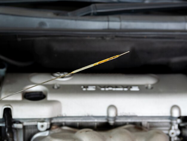 Photo hand of a mechanic oil dipstick of the car