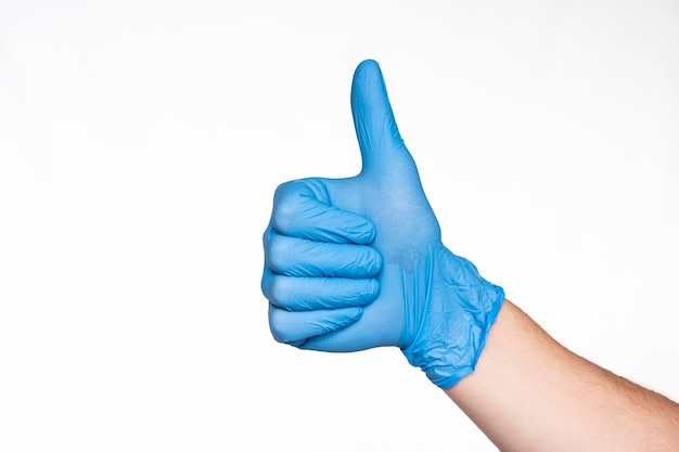 Hand in Medical Blue Latex Glove Giving Thumbs Up Sign. Like. White background. Protection concept