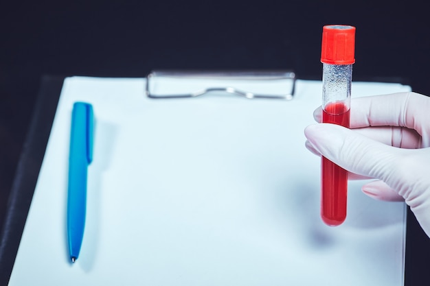 Photo a hand in a medical glove holds a test tube with dna.