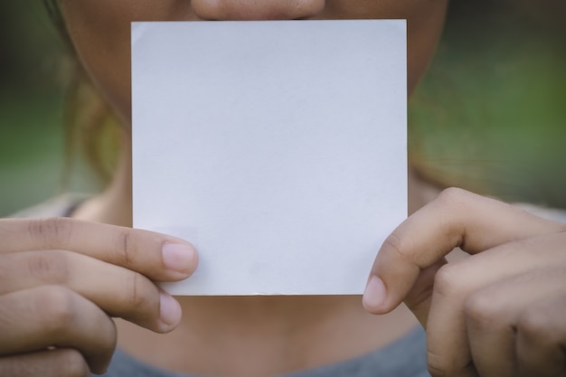 Hand met blanco papier op aard achtergrond.