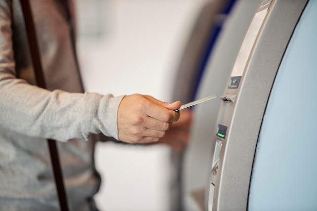 Hand met creditcard en gebruik van ATM