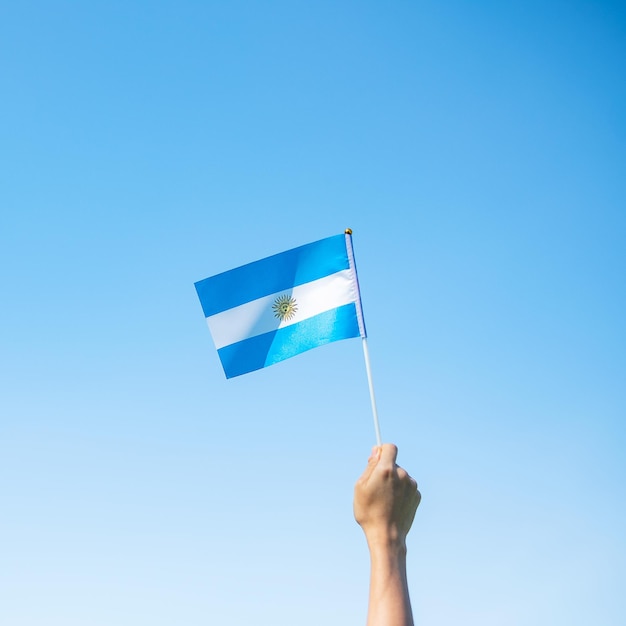 Hand met de vlag van Argentinië op de natuurachtergrond 9 juli van de onafhankelijkheidsdag 25 mei van de revolutiedag en gelukkige vieringsconcepten