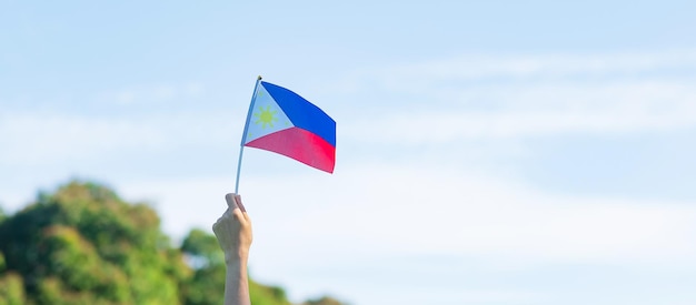 Hand met de vlag van de Filipijnen op de natuurachtergrond 12 juni van Onafhankelijkheidsdag en gelukkige vieringsconcepten