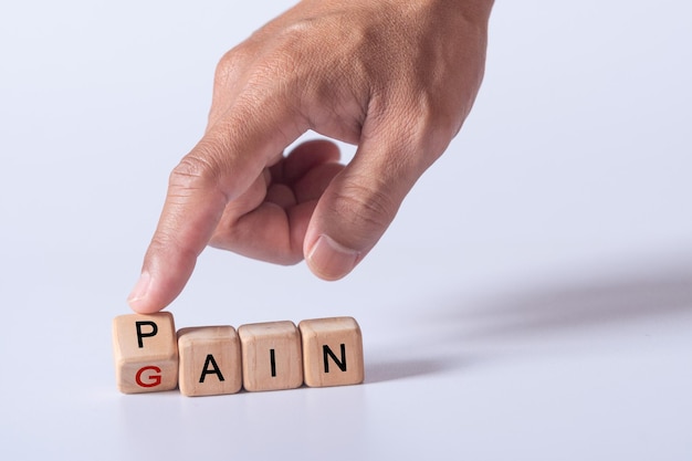 Hand met dobbelstenen met tekst ter illustratie van no pain no gain woorden