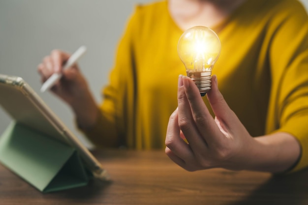 Hand met een gloeilamp. Communiceren over de opkomst van creatieve zakelijke ideeën of leren