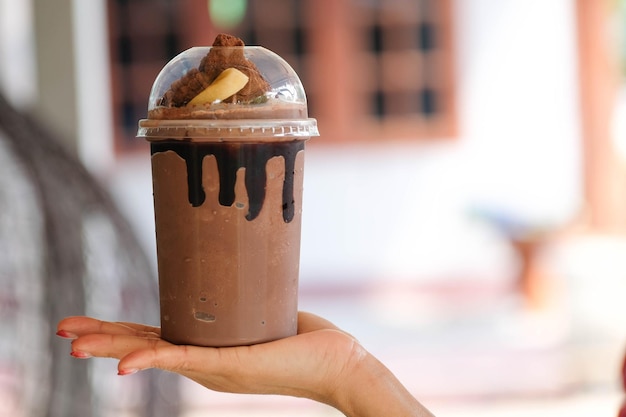 Hand met een kopje ijskoude cacao koffie cacao brownies stijlvolle coffeeshop