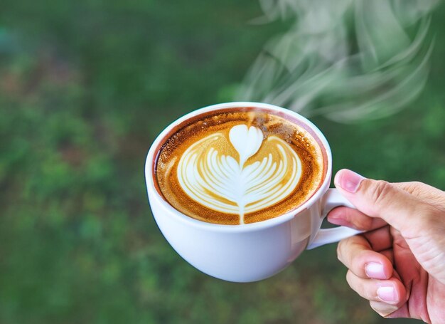 Hand met een Latte-koffiekopje Internationale koffiedag