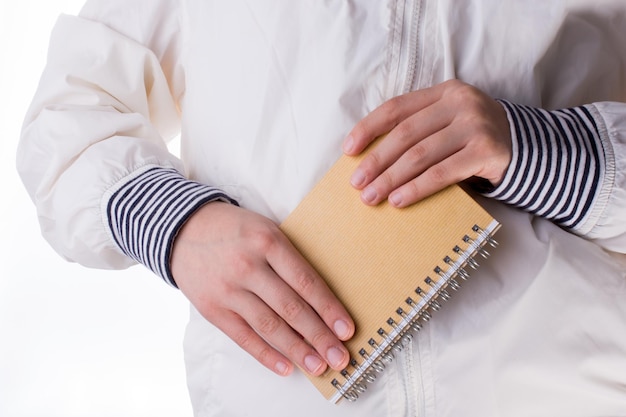 Hand met een notitieboekje op een witte achtergrond