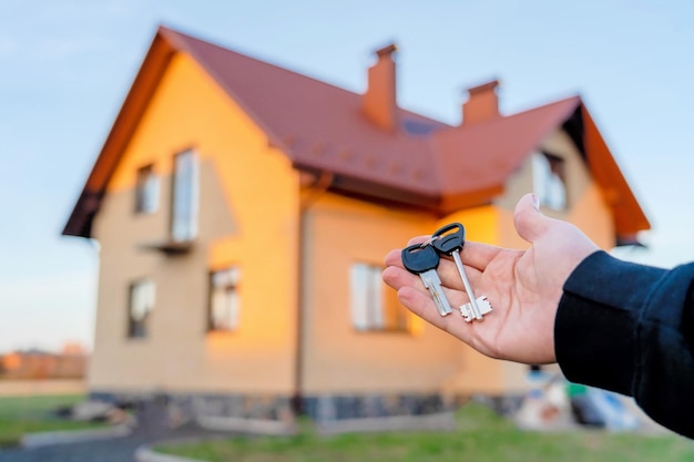 Hand met een sleutel voor het huis Bouwproject verhuizen naar een nieuw huis hypotheek huren en kopen onroerend goed