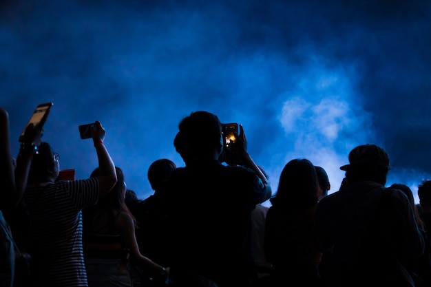 Foto hand met een smartphone neemt het festival van de livemuziek op, nemend foto van overlegstadium